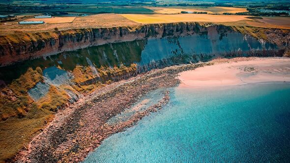 Aerial view of coastal cliff and sandy beach at Cayton Bay, Yorkshire