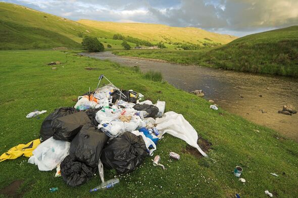 Fly tipping in the countryside, leaving rubbish against the River Eden, Cumbria