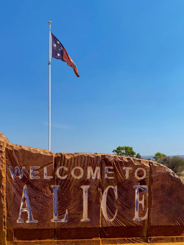 Northern Territory (NT) Flag Flying Above Welcome to Alice Springs Sign at City Entrance on Stuart Highway