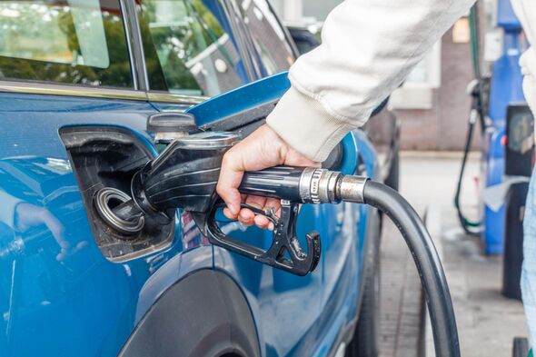 Close up of man hand refueling a blue car at a petrol station. Oil price crisis