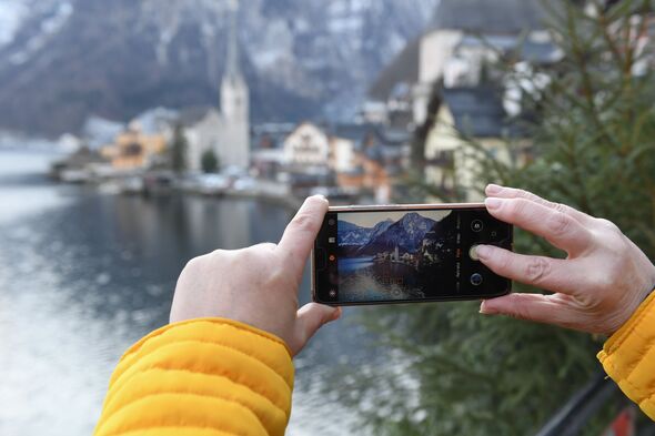 A person taking a photo of Hallstatt