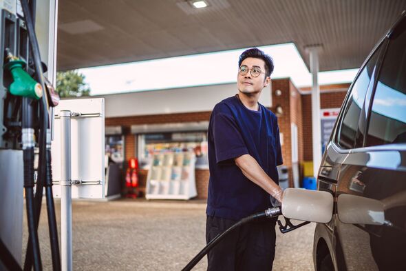 Man refuelling car at petrol station during everyday commute
