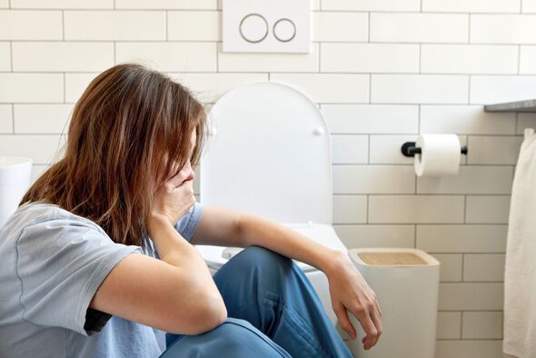 Young woman feeling sick and nauseous in bathroom