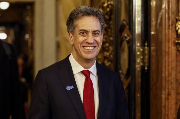 Ed Miliband smiles in suit with red tie