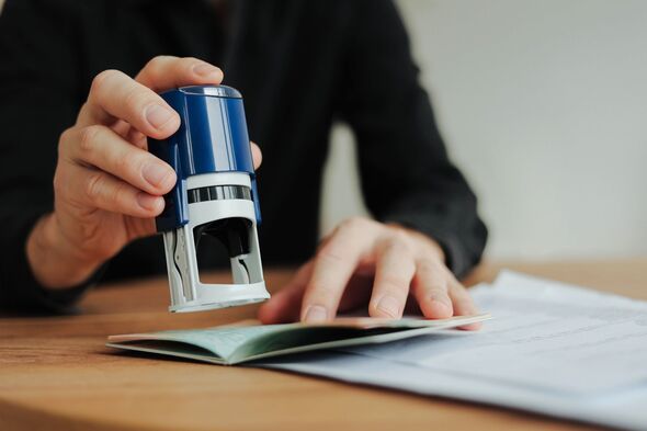 Man border control worker puts a stamp in passport