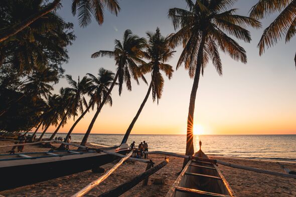 Ifaty, beach, pirogue and palm trees at sunset.