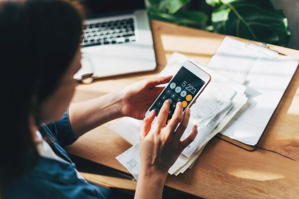 A woman looking at a phone calculator