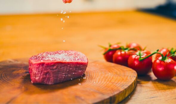Picture of someone salting a steak