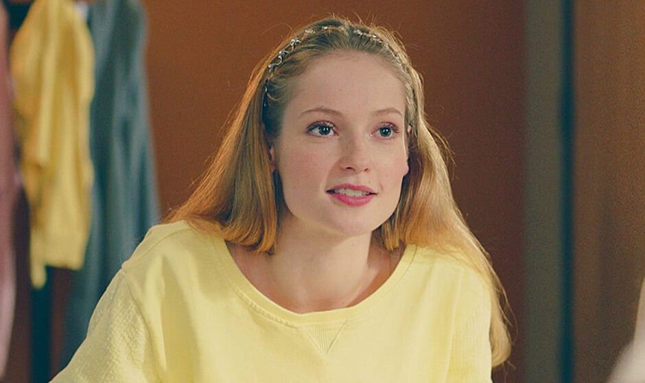 A girl in a yellow top smiles