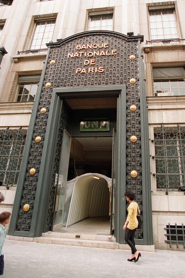 The front entrance of an ornate building, featuring a decorative sign above the door that reads