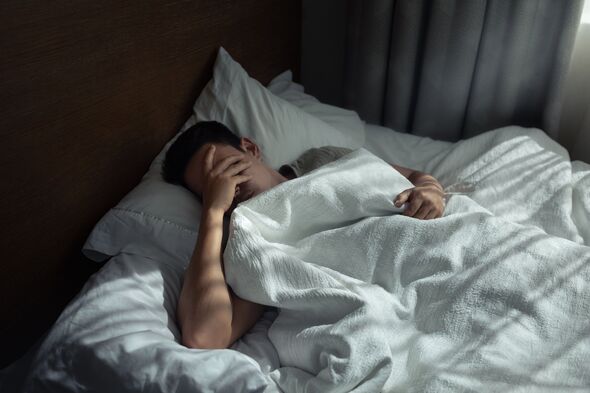 Sad lonely tired man home alone in bed suffering from insomnia, depression.