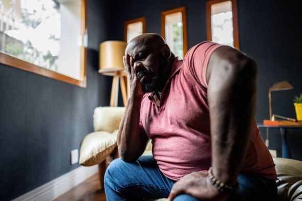 An individual dressed in a pink shirt in pain