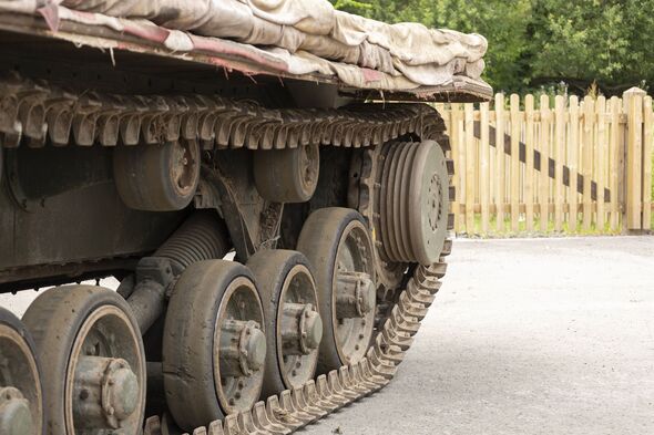 Depicts the detail of a tank's tracks outdoors