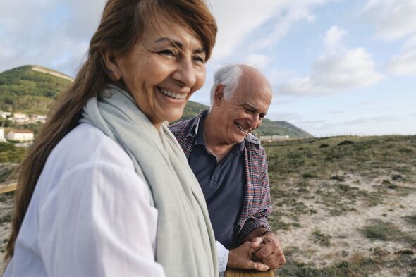 Happy senior woman with man in front of mountains