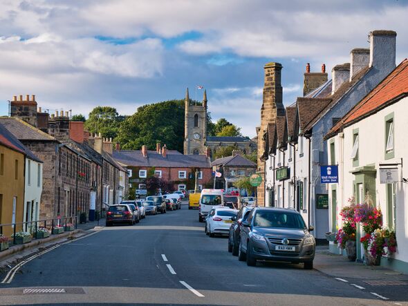Sandstone buildings and the busy high street and church in the centre of Belford
