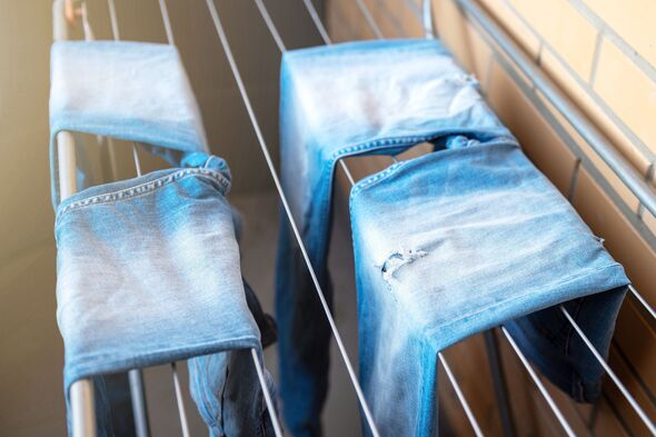 Jeans drying on the dryer. Wet blue jeans drying in the apartment on the dryer