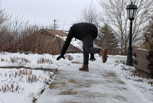 Risk of slipping on a slippery sidewalk in winter. A woman slipped on the ice