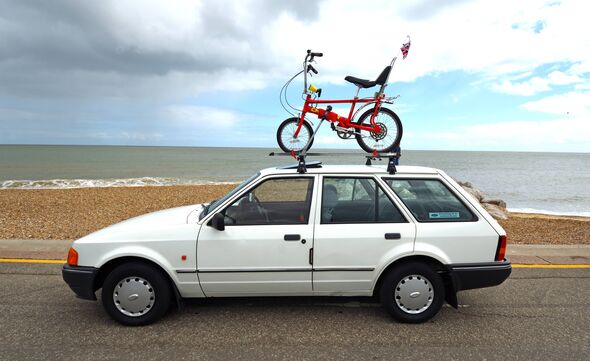 Felixstowe, Suffolk, England - May 04, 2025: Classic white Ford Escort Mk4 with Classic Raleigh Chopper bike on roof