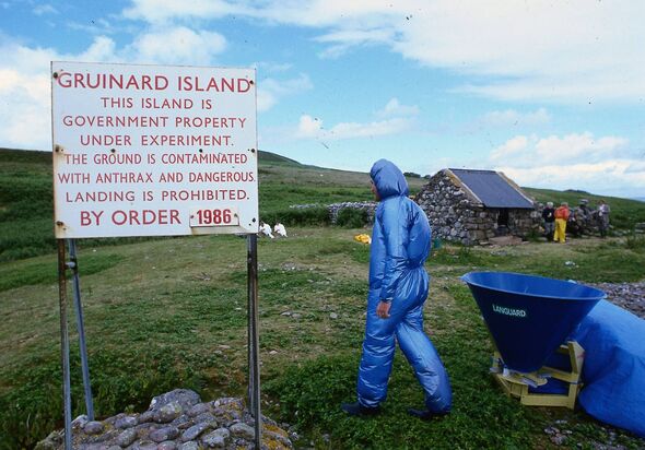 A scientist walks past a warning notice about anthrax contamination on Gruinard Island in July 1986