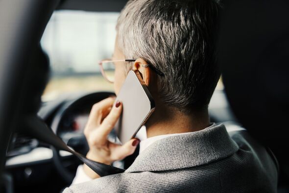 Businesswoman talking on phone while driving car