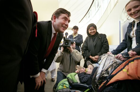 Chancellor Gordon Brown smiles at baby in pram