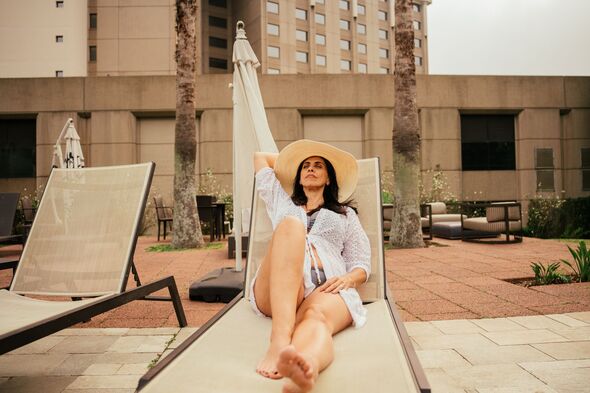 Mature woman on sun lounger in luxury hotel