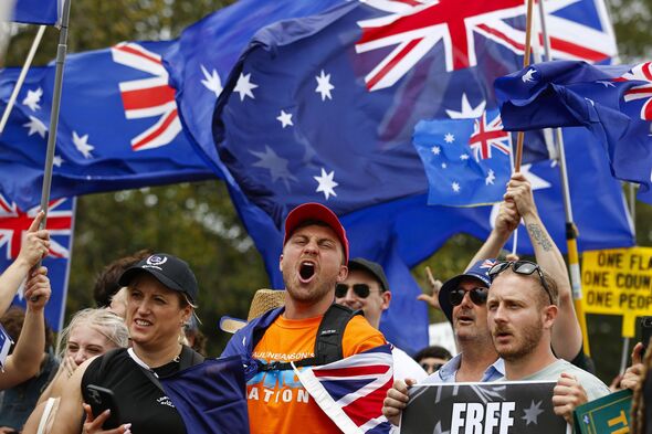 Protesters shout with banners and flags