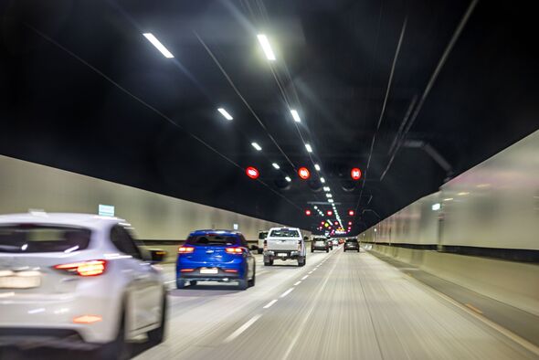 Cars driving in road tunnel, street lights highway