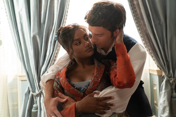 A man embraces a woman from behind as she caresses his face