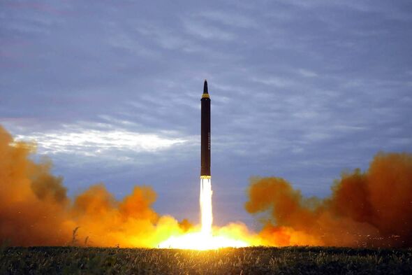 Shows North Korea's intermediate-range strategic ballistic rocket Hwasong-12 lifting off from the launching pad at an undisclosed location near Pyongy