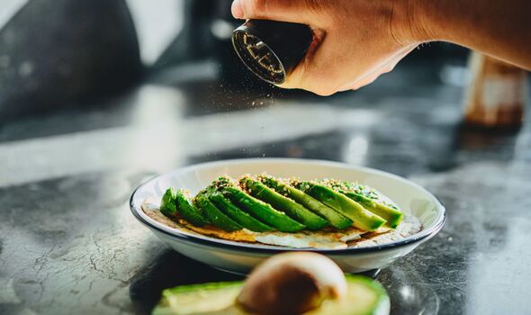 Picture of someone seasoning avocado toast