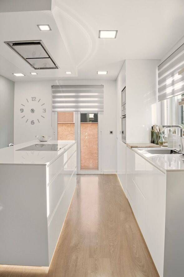 Modern kitchen interior featuring white cabinets and hardwood floor