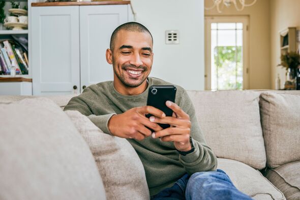 Man smiling while using smartphone