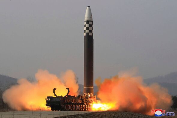 An image depicts the launch of a missile from a mobile platform, characterized by intense flames and smoke emanating from the ba