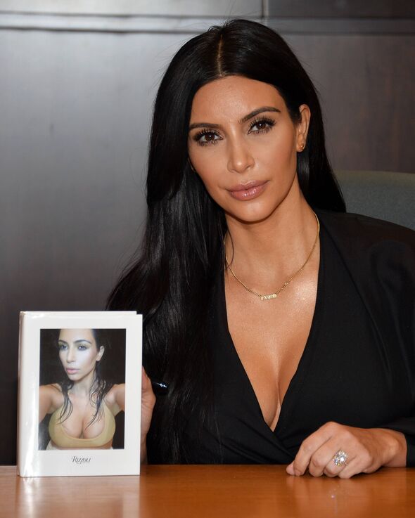 Kim Kardashian poses before signing copies of her book