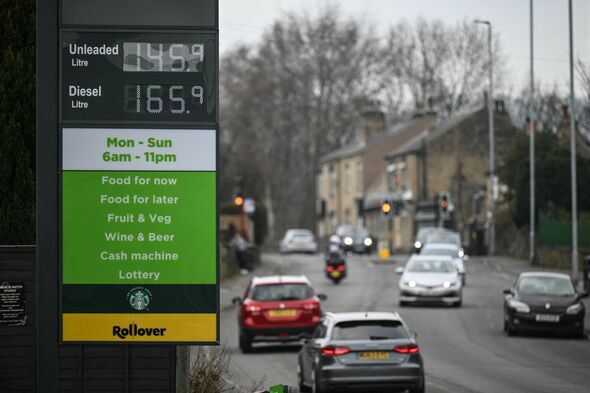 A signboard (L) showing prices for petrol and diesel is pictured at a petrol service station in Milnsbridge, suburban Huddersfie