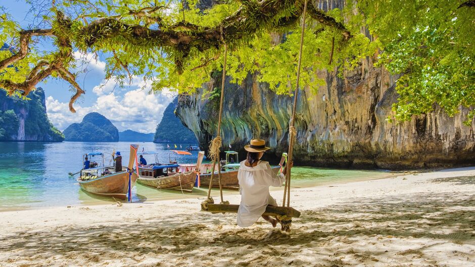 women on a swing at the Tropical lagoon of Koh Loa Lading Krabi Thailand part of Koh Hong Islands