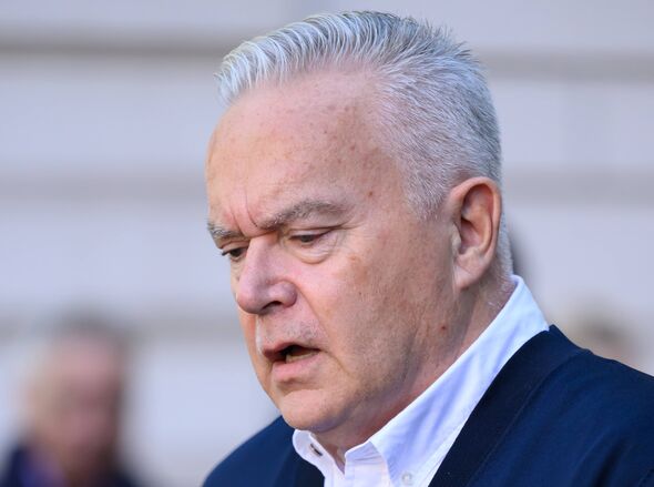 An adult male, dressed in formal attire, appears to be engaged in a serious conversation, with his eyes closed and a focused exp