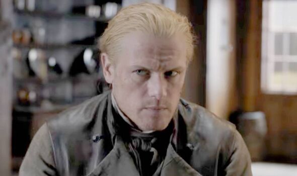 A man in brown looks serious