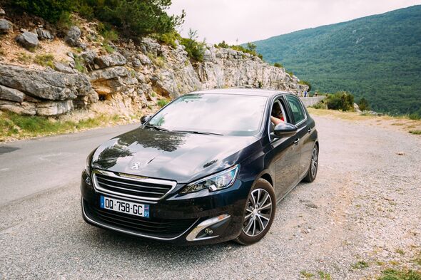 Black colour Peugeot 308 car on background of French mountains
