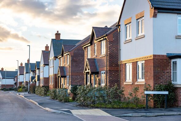 Houses in England with typical red bricks at sunset - Main street in a new estate with typical British houses on the side - Real estate and buildings