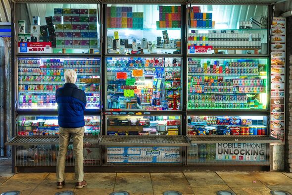 Senior man looking at disposable vapes at kiosk in London, UK