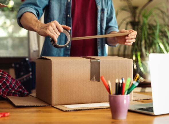 Man sealing parcel with duct tape