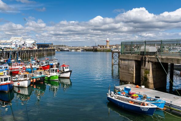 Dunmore East, Ireland - 17 August, 2022: view of the Dunmore East harbour and lighthouse in County Waterford