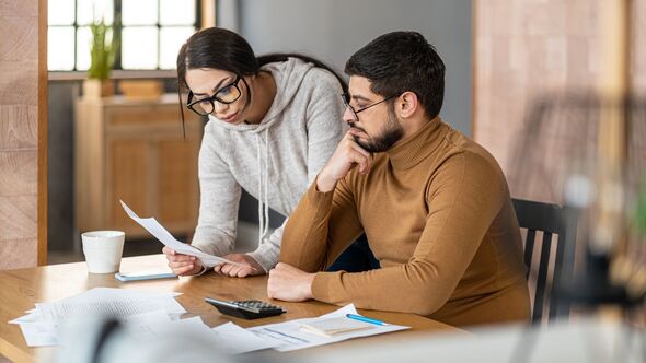 Couple managing home finances, reviewing expenses and accounting