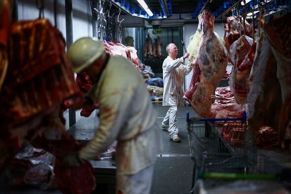 Butchers handle meat in fridge at Smithfield