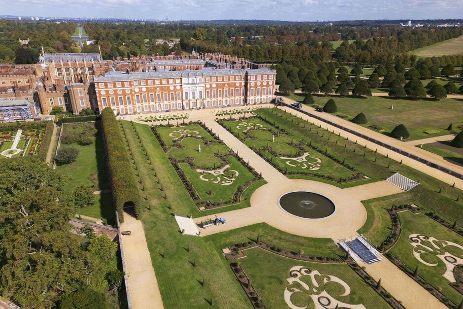 Aerial view of the spectacular architecture of Hampton Court Palace and Gardens on the banks of the River Thames.