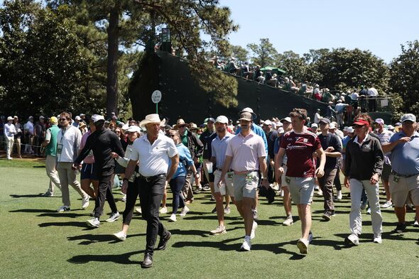 Greg Norman walks with patrons at Augusta National