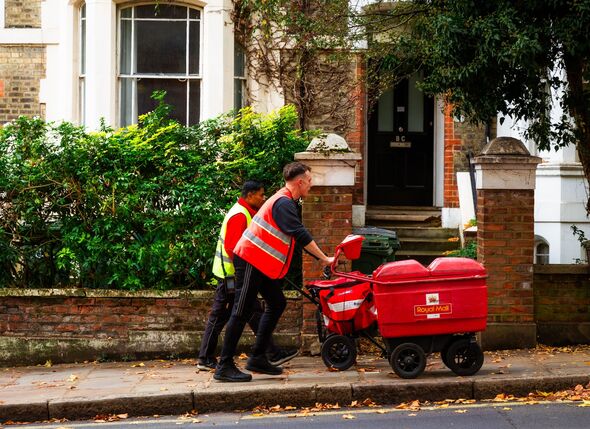 Royal Mail postman pushing mail trolley on street.