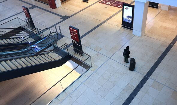 A lone passenger stands at the Berlin-Brandenburg airport in Schoenefeld